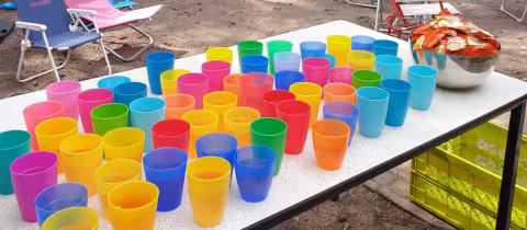 Gekleurde bekers op een tafel onder de vlaggetjes