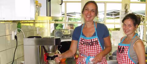 Twee keukenmedewerkers aan het werk in de kampkeuken