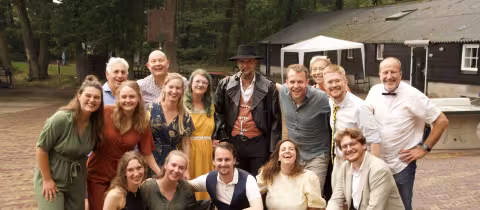 Lachend leidingteam poseert samen op het groene kampterrein