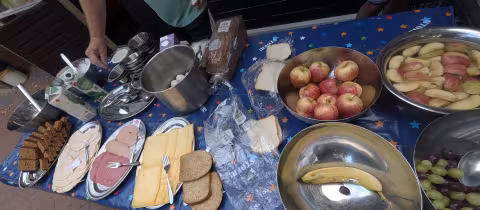 Leiding bereidt een uitgebreid ontbijt met brood, fruit en beleg voor