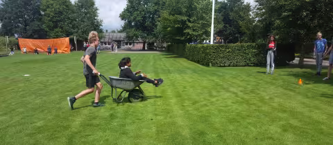 Deelnemer rijdt met een bolderkar over het grasveld
