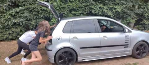 Deelnemers laden bagage in een auto