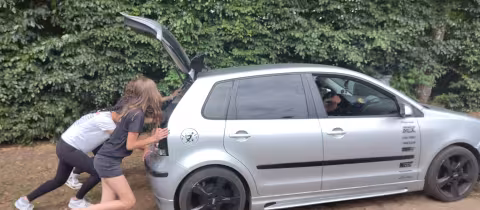 Deelnemers laden bagage in een auto