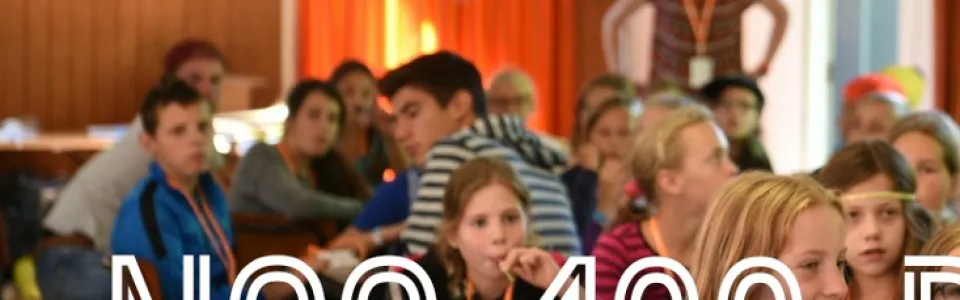 Deelnemers in een zaal met de tekst NOG 100 DAGEN eroverheen