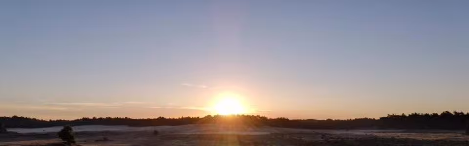 Zonsondergang boven de zandvlakte met deelnemers
