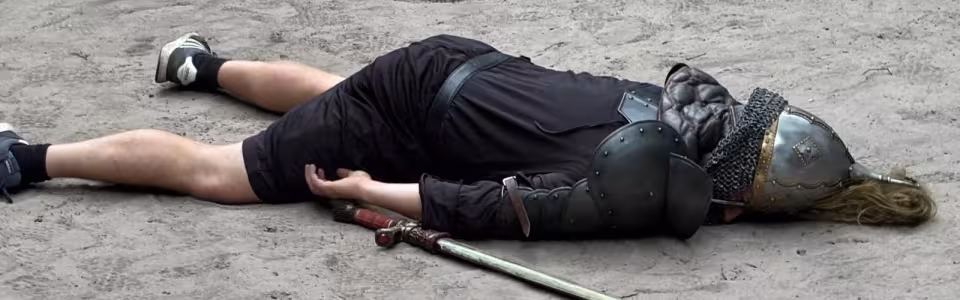 Deelnemer ligt in het zand na het spel Goliath