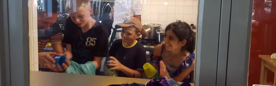 Deelnemers bij het doorgeefluik van de keuken