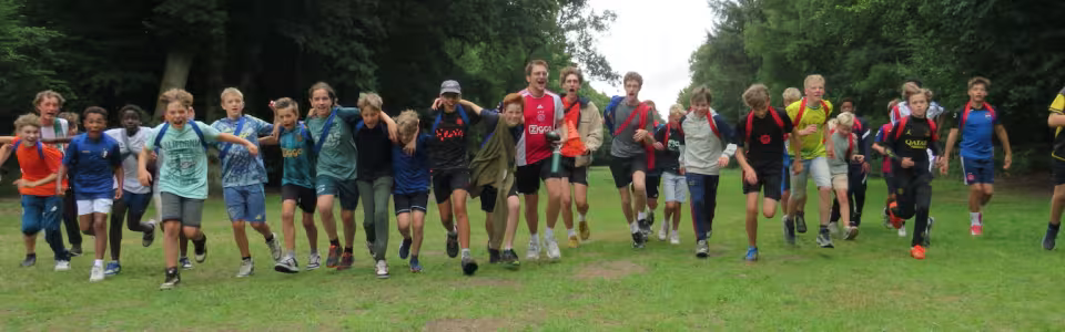 Deelnemers staan in een grote kring op het grasveld