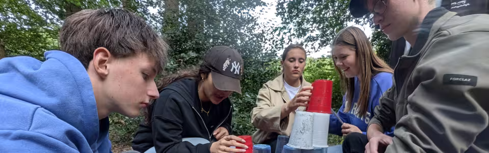 Deelnemers bouwen een toren van bekers