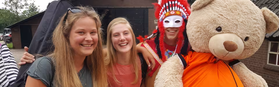 Deelnemers met een indianentooi en een grote knuffelbeer