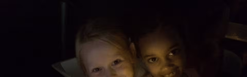 Twee kinderen met lichtjes in het donker