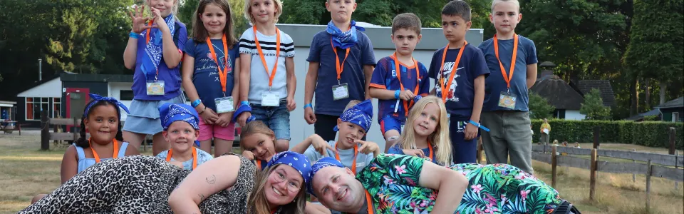 Kinderen en leiding poseren vrolijk samen rond de tafeltennistafel