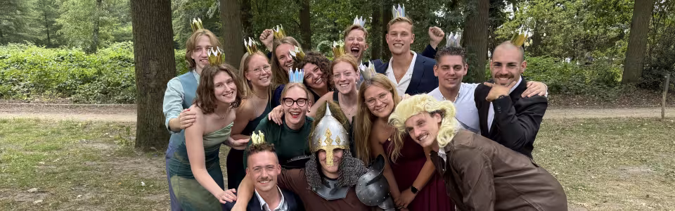 Verklede kampleiding poseert feestelijk met kroontjes in het bos