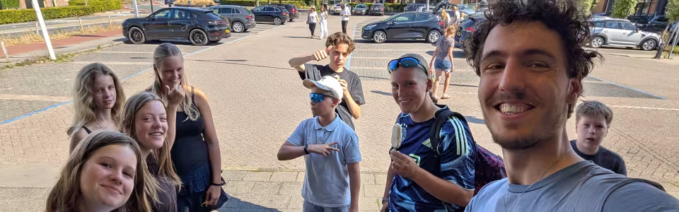 Tieners genieten samen van een ijsje tijdens het tienerkamp.