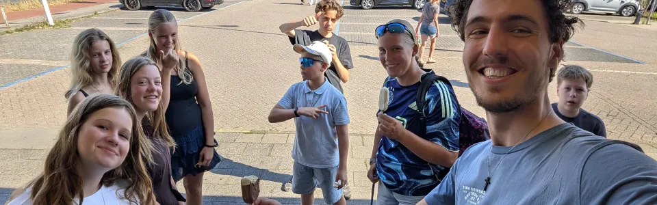 Tieners genieten samen van een ijsje tijdens het tienerkamp.