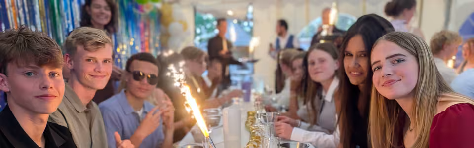Deelnemers aan een feestelijk gedekte tafel