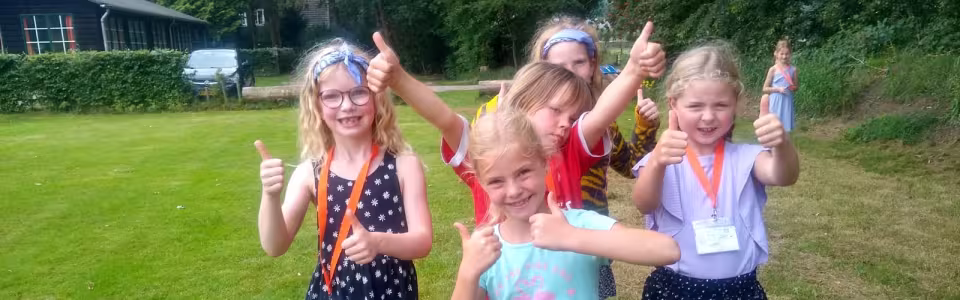Deelnemers poseren op het grasveld