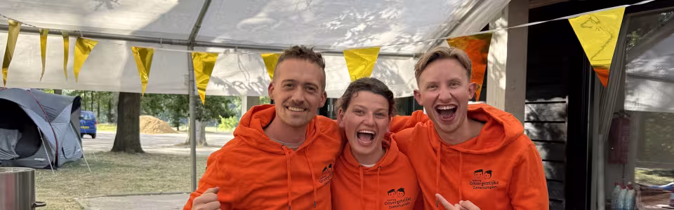 Kampleiding in oranje jassen in de tent