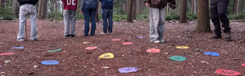 Tieners spelen samen een kleurrijk cijferspel in het bos