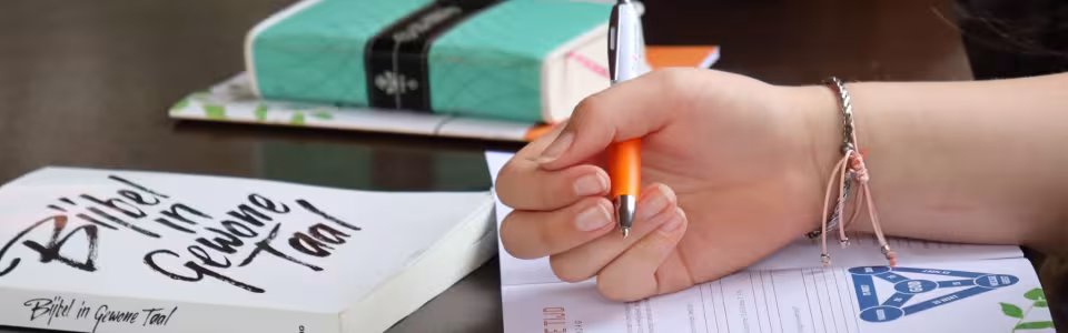 Bijbel, notitieboek en pen op tafel tijdens het ochtendprogramma