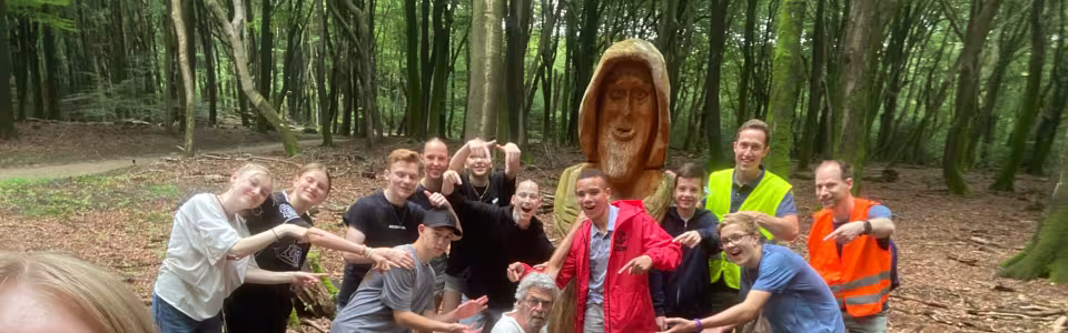 Deelnemers poseren op een bospad
