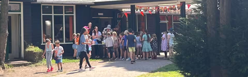 Kinderen verzamelen zich rond de uitgifte bij het kamphuis
