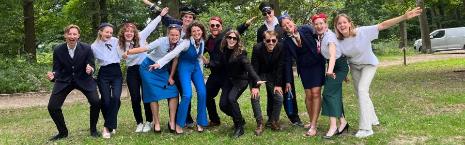 Kampleiding poseert uitbundig in pilotenuniformen tussen de bomen
