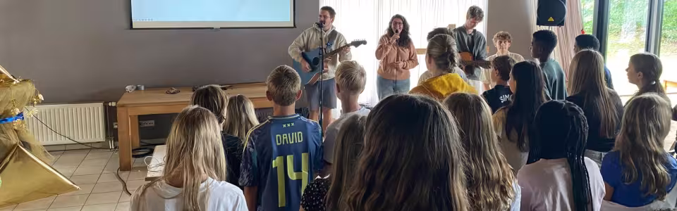 Deelnemers staan in de zaal tijdens het programma