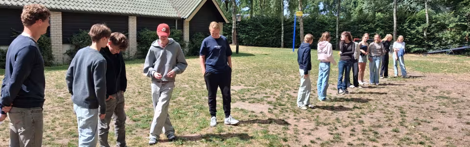 Deelnemers spelen een spel op het zandveld