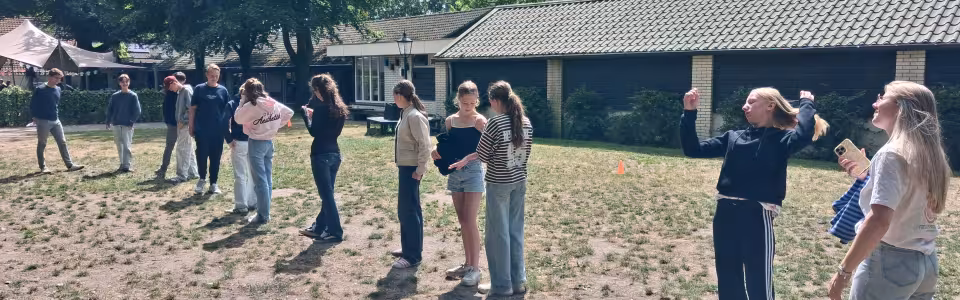 Deelnemers spelen een spel op het zandveld
