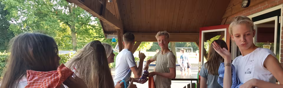 Deelnemers aan tafel onder een overkapping
