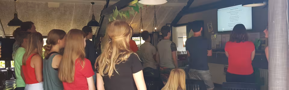 Deelnemers staan te kijken in de zaal