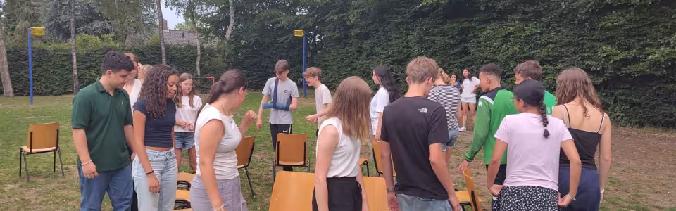 Deelnemers spelen een stoelendans op het grasveld