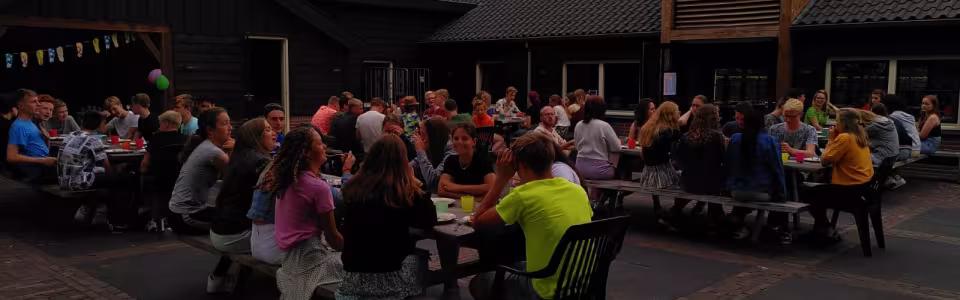Deelnemers aan tafels op het terras in de avond