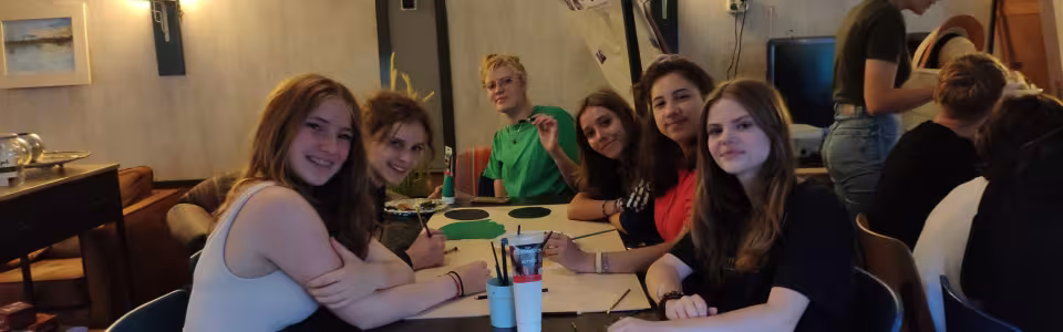 Deelnemers zitten aan tafel in de eetzaal