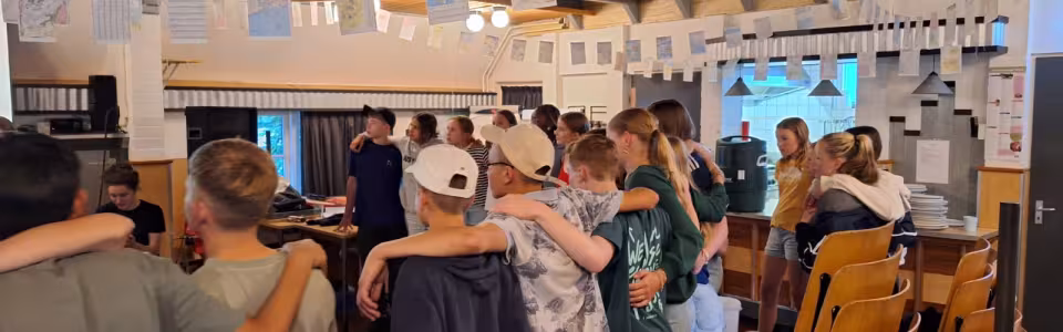 Deelnemers staan in een kring in de zaal