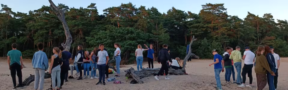 Deelnemers verzamelen zich op de zandvlakte bij avondlicht
