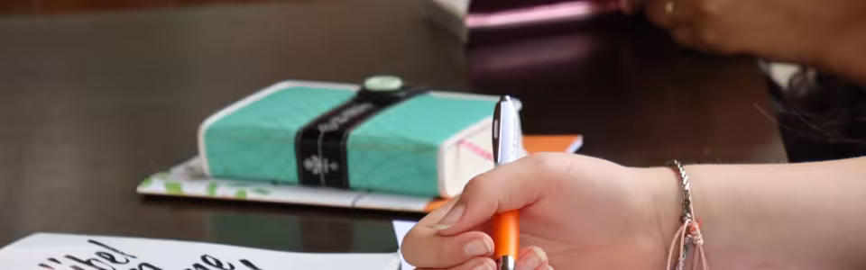 Deelnemer schrijft in een boekje aan tafel