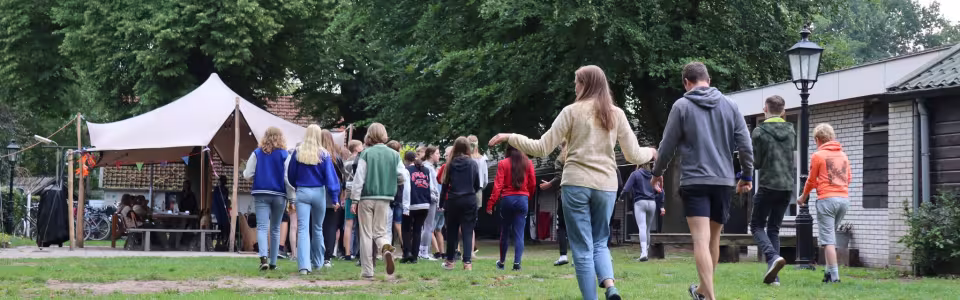 Deelnemers lopen over het terrein op de aankomstdag