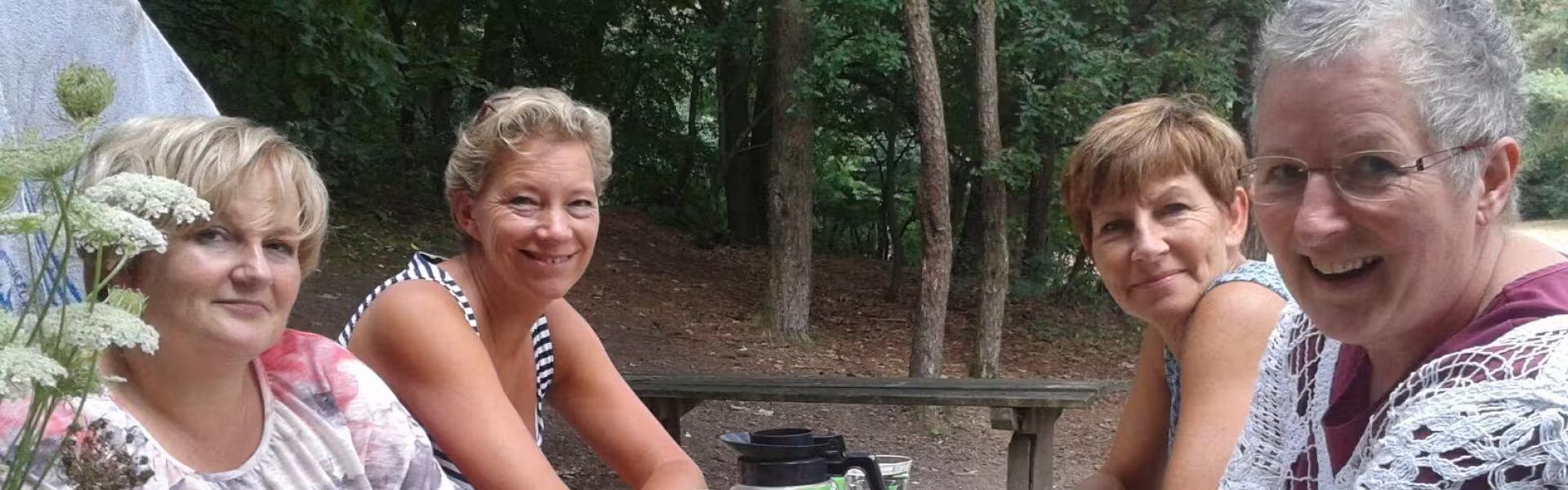 Keukenteam aan een picknicktafel met koffie