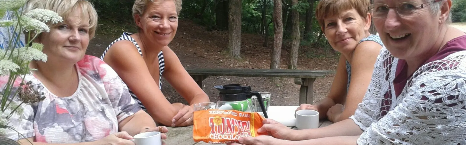 Keukenteam aan een picknicktafel met koffie