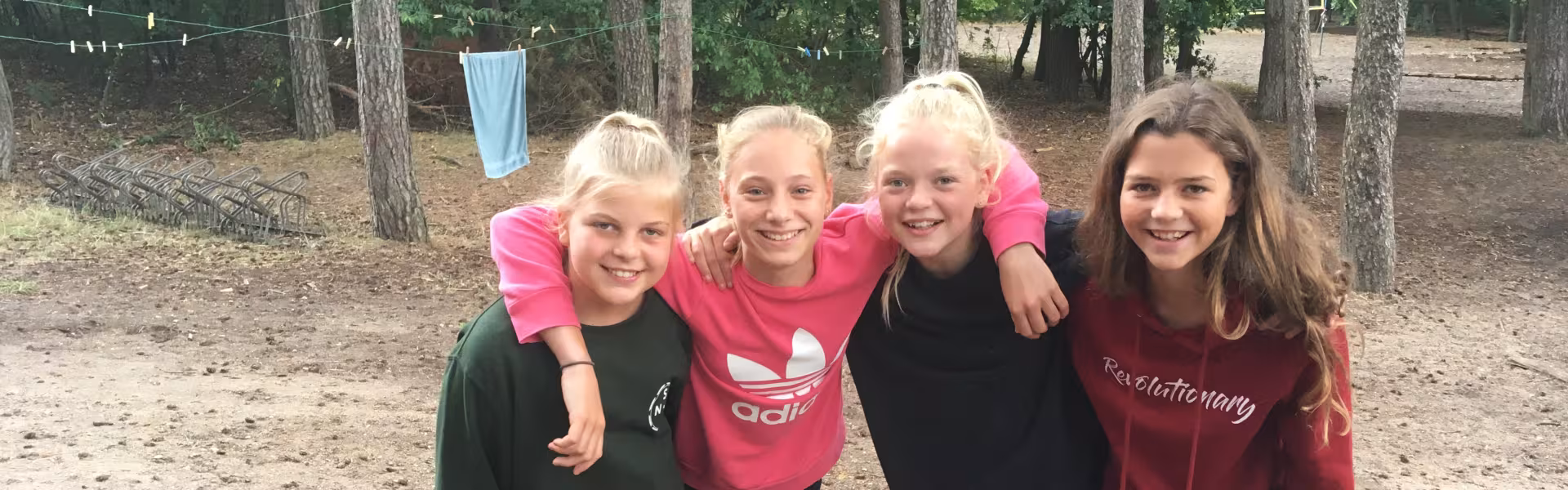 Vier meisjes poseren in het zand