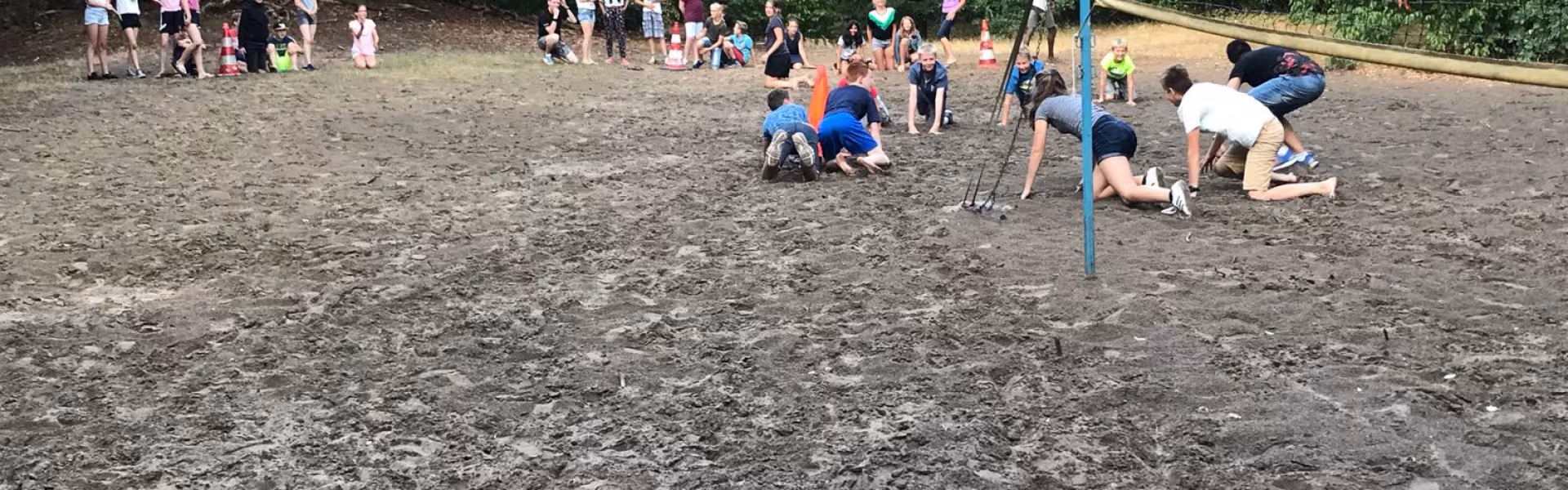 Deelnemers op het volleybalveld in het zand