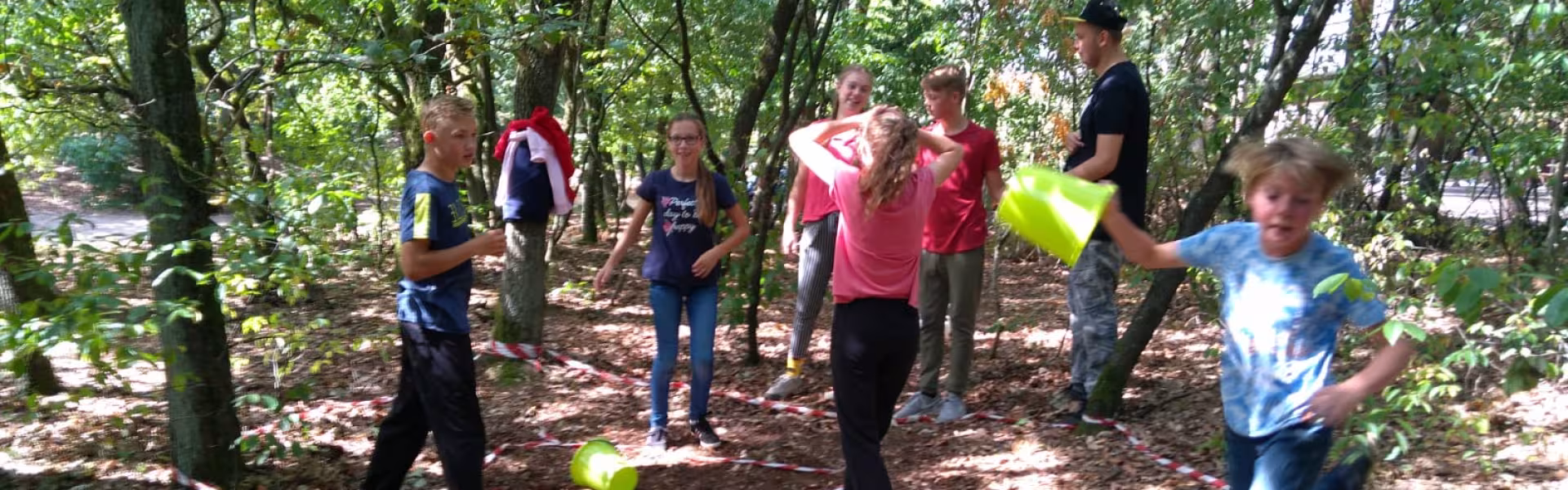 Deelnemers spelen een spel tussen de bomen