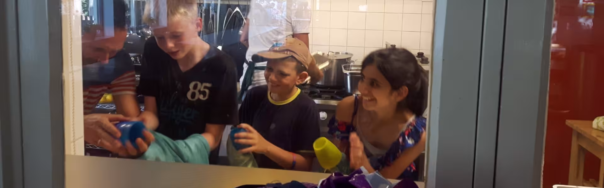 Deelnemers bij het doorgeefluik van de keuken