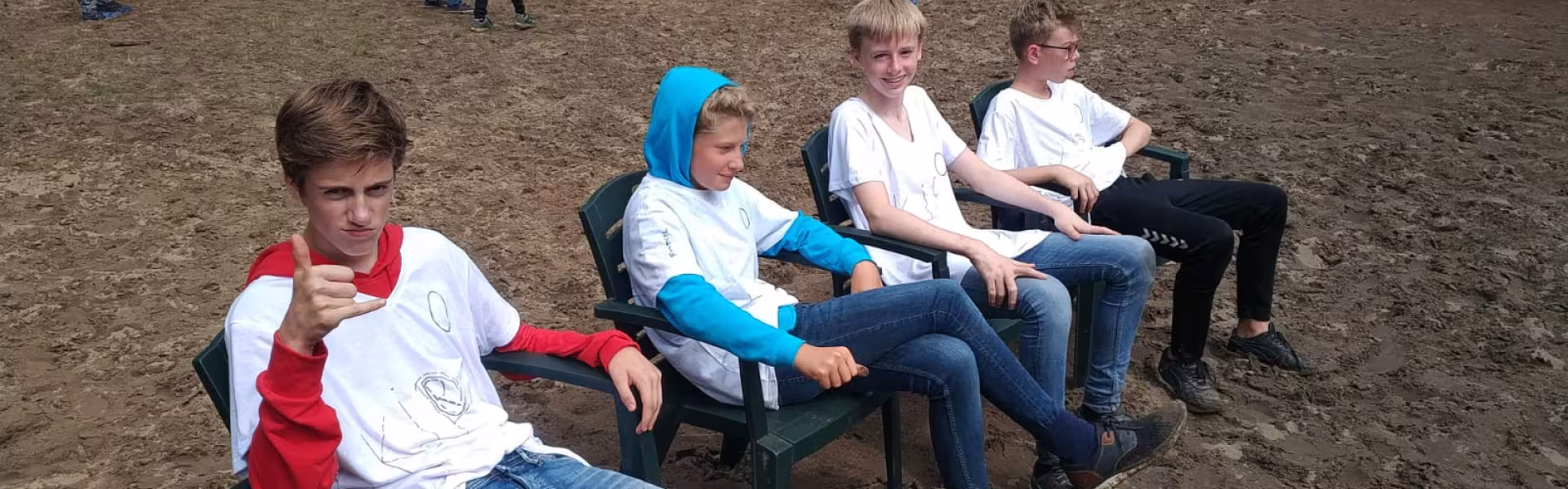 Deelnemers spelen touwtrekken in het zand