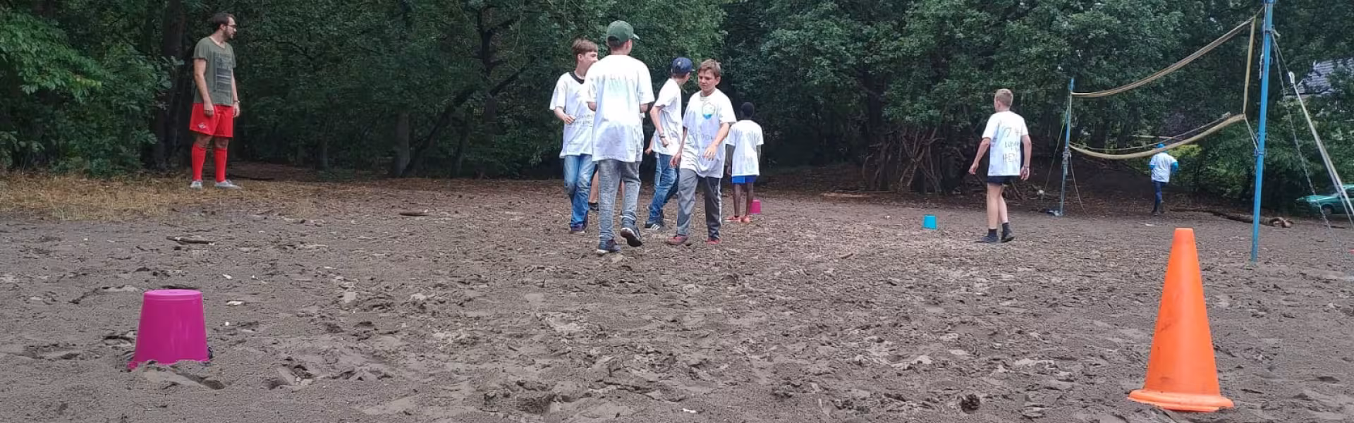 Deelnemers spelen een spel op het zandveld