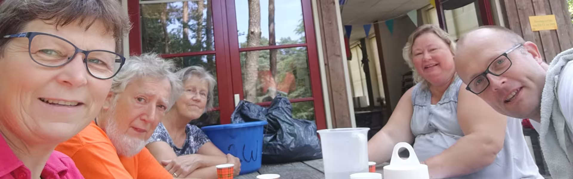 Keukenteam aan tafel bij het kampgebouw