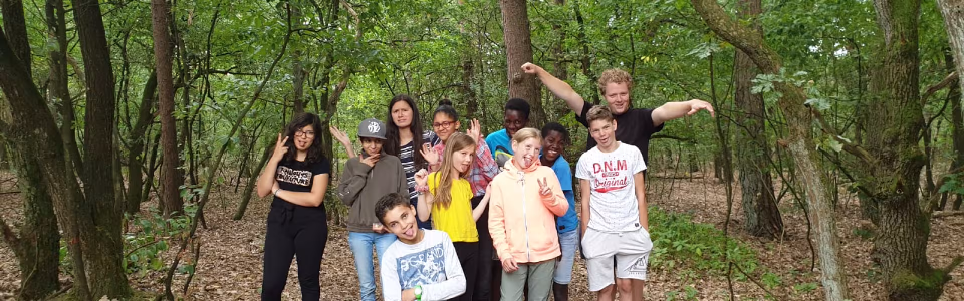 Deelnemers poseren in het bos