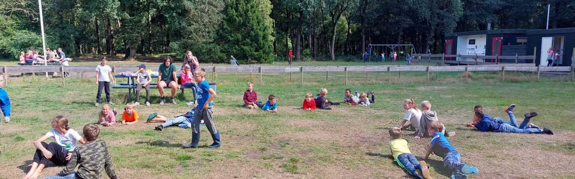 Deelnemers spelen een waterspel op het terrein